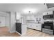 Updated kitchen features white cabinetry, modern light fixture, stainless appliances and luxury vinyl plank flooring at 5136 Miller St, Indianapolis, IN 46241