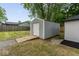A storage shed in the backyard offers space for storage, with a wooden ramp and gravel surround at 5136 Miller St, Indianapolis, IN 46241