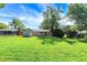 Spacious backyard with mature trees, lush lawn, and charming home exterior at 5236 Daniel Dr, Indianapolis, IN 46226