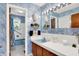 Charming bathroom featuring vintage blue fixtures, floral wallpaper, and a well-lit vanity area at 5236 Daniel Dr, Indianapolis, IN 46226