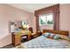 Bedroom featuring a bed with floral comforter, vanity area, window, and neutral walls at 5236 Daniel Dr, Indianapolis, IN 46226