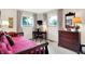 Bedroom with two windows, wood dresser, desk, and bed with dark red comforter at 5236 Daniel Dr, Indianapolis, IN 46226
