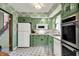 Well-lit kitchen featuring white appliances, ample storage, and green cabinets at 5236 Daniel Dr, Indianapolis, IN 46226