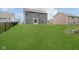 Well-kept backyard with a vast lawn, bordered by a black metal fence, providing a secure and scenic outdoor space at 5335 Rum Cherry Way, Indianapolis, IN 46237