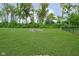 Spacious backyard featuring a well-maintained lawn and a rustic fire pit area, perfect for outdoor gatherings at 5335 Rum Cherry Way, Indianapolis, IN 46237