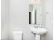 A half bathroom with a pedestal sink, mirror, toilet, and towel rack at 5335 Rum Cherry Way, Indianapolis, IN 46237