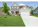 Inviting two-story home with landscaped lawn and a charming covered front porch and white two car garage at 5335 Rum Cherry Way, Indianapolis, IN 46237