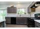 A well-lit kitchen features dark cabinetry, laminate countertops, and black appliances at 5335 Rum Cherry Way, Indianapolis, IN 46237