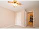 Well lit bedroom, including ceiling fan, carpeted floor, and a view into an ensuite at 5352 Steinmeier N Dr, Indianapolis, IN 46220