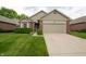 Charming single-story home featuring a brick facade, well-maintained lawn, and attached garage at 5352 Steinmeier N Dr, Indianapolis, IN 46220
