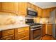 Bright kitchen featuring stainless steel appliances, wooden cabinets, and granite countertops at 5352 Steinmeier N Dr, Indianapolis, IN 46220