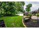 Expansive backyard featuring a lush lawn, brick patio, garage, and planter boxes at 5677 Carrollton Ave, Indianapolis, IN 46220