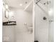 Full bathroom features a glass enclosed shower, black granite counter, and mosaic tile flooring at 5677 Carrollton Ave, Indianapolis, IN 46220