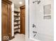Modern bathroom with tiled shower, built-in shelves, and decorative wood trim, offering spa-like experience at 5677 Carrollton Ave, Indianapolis, IN 46220