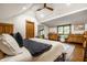 Comfortable bedroom featuring hardwood floors, a ceiling fan, and natural wood trim at 5677 Carrollton Ave, Indianapolis, IN 46220