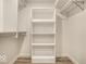 Walk-in closet with custom built-in white shelving and plank flooring at 5677 Carrollton Ave, Indianapolis, IN 46220