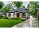 Charming brick home with lush landscaping, updated windows, and a brick chimney at 5677 Carrollton Ave, Indianapolis, IN 46220