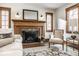 Cozy living room fireplace with classic wood mantle, tiled hearth and light filled windows at 5677 Carrollton Ave, Indianapolis, IN 46220