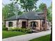 Beautiful brick home showcasing lush landscaping, a unique turret, and a welcoming pathway at 5677 Carrollton Ave, Indianapolis, IN 46220