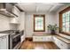 Modern kitchen with stainless steel appliances, and a cozy bench with built-in storage at 5677 Carrollton Ave, Indianapolis, IN 46220