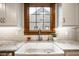 Close-up of a farmhouse sink with granite countertops and subway tile backsplash at 5677 Carrollton Ave, Indianapolis, IN 46220