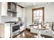 Charming kitchen features stainless steel appliances, white cabinets, and breakfast nook with built-in seating at 5677 Carrollton Ave, Indianapolis, IN 46220