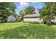 Spacious backyard featuring a detached garage and mature trees offering shade at 6125 Winthrop Ave, Indianapolis, IN 46220