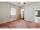 Bedroom with pink carpet, white walls, ceiling fan, and closet with shelving at 6125 Winthrop Ave, Indianapolis, IN 46220