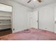Bedroom featuring pink carpet, white walls, and a closet with built-in shelving at 6125 Winthrop Ave, Indianapolis, IN 46220