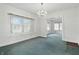 An empty dining room with an ornate chandelier, a built-in storage unit under the windows and bright natural light at 6125 Winthrop Ave, Indianapolis, IN 46220