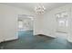A bright, empty dining room with an ornate chandelier and easy access to the living room and other rooms at 6125 Winthrop Ave, Indianapolis, IN 46220