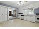 Traditional kitchen with white cabinets and appliances, view to Gathering room, and neutral countertops and flooring at 6125 Winthrop Ave, Indianapolis, IN 46220