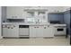 Bright kitchen features white cabinets and appliances, window over sink, and neutral countertops and flooring at 6125 Winthrop Ave, Indianapolis, IN 46220