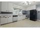 Traditional kitchen features white cabinetry, neutral countertops and flooring, and black refrigerator at 6125 Winthrop Ave, Indianapolis, IN 46220