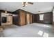 Spacious living room with wood paneling, carpeted floors, closets, and view to kitchen at 6125 Winthrop Ave, Indianapolis, IN 46220