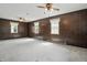 Cozy living room with wood paneling, carpeted floors, and three windows for natural light at 6125 Winthrop Ave, Indianapolis, IN 46220
