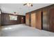 Cozy living room with wood paneling, carpeted floors, with closets and doors at 6125 Winthrop Ave, Indianapolis, IN 46220