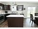 Charming kitchen with dark cabinets, tile backsplash, stainless appliances and center island at 680 Albermarle Dr, Pittsboro, IN 46167
