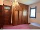 Bedroom with ample storage, showcasing built-in wardrobes, classic door, and comfortable bed at 712 Cottage Ave, Anderson, IN 46012