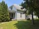 Traditional two-story home with covered porch and mature trees on a well-maintained lawn at 712 Cottage Ave, Anderson, IN 46012