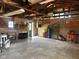 Large garage interior with storage cabinets, open ceiling, and concrete flooring at 712 Cottage Ave, Anderson, IN 46012