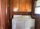 Functional laundry room features washer, dryer, and above storage cabinets near window at 712 Cottage Ave, Anderson, IN 46012