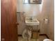 Compact powder room features classic sink and toilet with convenient accessories at 712 Cottage Ave, Anderson, IN 46012