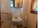 Compact powder room features classic sink and toilet with convenient accessories and mirror at 712 Cottage Ave, Anderson, IN 46012