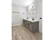 Modern bathroom with double sinks, gray cabinets, black hardware, and wood-look floors at 716 Royal Troon Ct, Avon, IN 46123