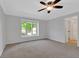 Well-lit carpeted bedroom with ceiling fan, crown molding, and large window at 716 Royal Troon Ct, Avon, IN 46123