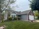A charming single-story home with a well-manicured lawn, brick and grey siding, and attached garage at 7175 Oakview Dr, Avon, IN 46123
