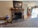 A brick fireplace with pig figurines on the mantle sits in the living room next to the kitchen at 7175 Oakview Dr, Avon, IN 46123