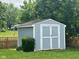 A well-maintained shed with white trim offers extra storage space in a landscaped backyard at 7175 Oakview Dr, Avon, IN 46123