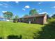Expansive backyard with well-maintained lawn and a brick home with a small wooden deck at 724 Iroquois St, Anderson, IN 46012
